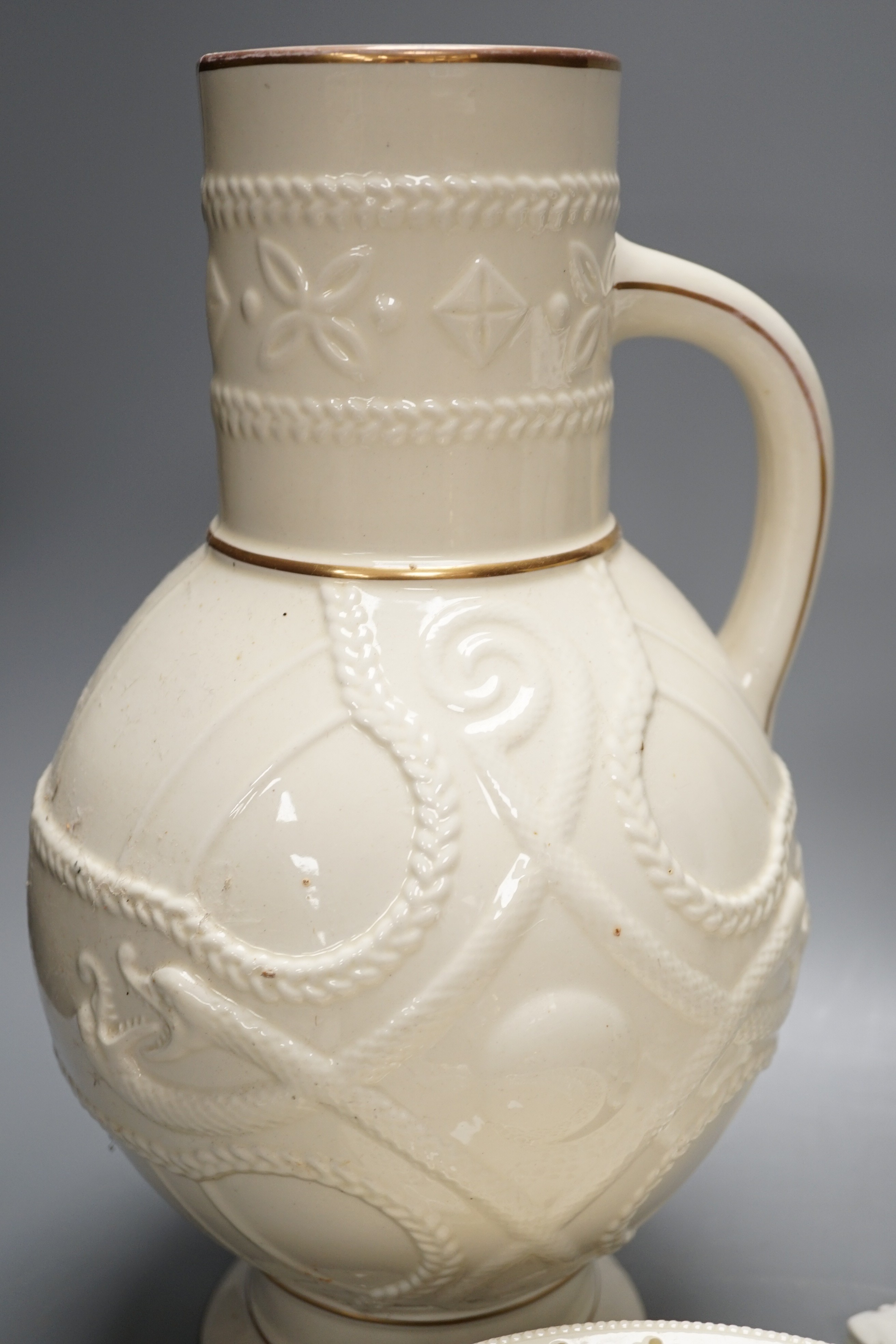 A set of seven early 19th century creamware plates, four later creamware candlesticks and an ivory ground jug. Tallest piece 33cm